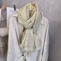 Close-up of beige cotton scarf featuring elegant floral lace trim and delicate tassels - Off White