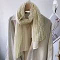 Detail of light yellow lace scarf with white polka dot embroidery and scalloped edges - Beige