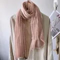 Close-up of soft pink linen scarf featuring white polka dot patterns and sheer texture - Pink