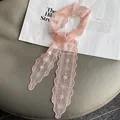 Close-up of pink lace scarf with floral embroidery and scalloped edges for hair - Pink