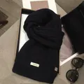 Detail of 100% wool scarf showing heavy cable knit texture and premium quality label - 170*30cm / Black