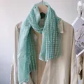 Close-up of mint green lace scarf with white polka dot embroidery and wavy edges - Green