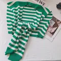 Detail of green and white striped knit shawl with H.STUDIO woven label and ribbed edges - Grass Green