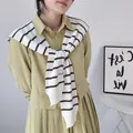 Close-up of the black and white striped knitted shawl draped over a pleated dress - Tops / White Double Black Stripes / 42x100cm