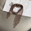 Detail of brown lace neck scarf with floral embroidery and wavy scalloped edges - Brown