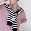 Detail of the black and white striped knit shawl with a white stitched label over a pink shirt - Tops / Black & White Wide Stripes / 42x100cm