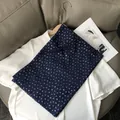 Gros plan sur l'écharpe en coton et lin bleu foncé avec d'élégants motifs de cerises dorés - Bleu marine