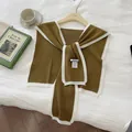 Nahaufnahme des olivgrünen Strickschals mit weißem Kontrastrand und HILLDI-Markenetikett - Kaffeebraun