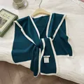 Detail of knit fabric texture and material label of this chic lake blue wool capelet - Aqua Blue