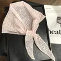 Close-up of light pink lace headband with floral butterfly patterns and scalloped edges - 28x115cm / Pink