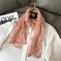 Detail eines rosa Spitzenschals mit Blumenstickerei und Wellenkante auf weißer Bluse - Rosa