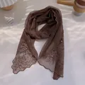 Detail of brown lace scarf with floral embroidery and white pearl beads on wavy edges - Coffee