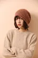 Detailed close-up of orange-brown melange knit beanie with thick ribbed texture - Orange