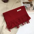 Detail of red 100% Australian wool scarf featuring long fringe and wool woven label - 180*30cm / Christmas Red
