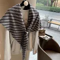 Close-up of black and grey striped wool scarf with white buckle on a grey sweatshirt - Striped Gray