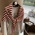 Detail view of a red and white striped wool triangle scarf draped over a grey hoodie - Wine Red Stripe