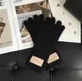Damen Strickhandschuhe aus Wolle in Schwarz mit Touch-Funktion und Aufnäher am Handgelenk - Schwarz