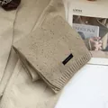 Detail of 100% wool speckled scarf in oatmeal with knit texture and material tag - Off White