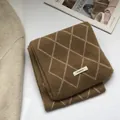 Detail of 100% wool knit scarf featuring a brown diamond pattern and fabric label - Khaki