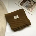 Dettaglio della sciarpa in 100% lana australiana marrone scuro con bordo a costine - Cammello