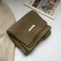 Close-up of 100% pure wool thick rib-knit scarf in camel with a soft woven texture - Peanut Camel