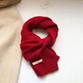 Detailed knit texture of a dark red 100% wool scarf with classic cable stitch patterns - Red