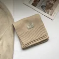 Detailed view of beige 100% Australian wool scarf featuring a fine knit texture and ribbed edge - Cream Rice