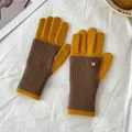 Detail view of contrast knit gloves in yellow and brown with decorative metal emblem - Yellow + Khaki
