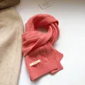 Dettaglio sciarpa di lana rosa corallo con maglia a trecce ed etichetta 100% pura lana - Rosa Arancio