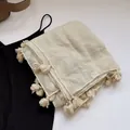 Dettaglio di una sciarpa beige in lino e cotone con fini frange su sfondo bianco - Beige
