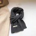 Dettaglio della sciarpa in lana grigio scuro con trama a trecce spesse ed etichetta - grigio scuro