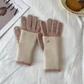 Close-up of knit winter gloves with touchscreen tips and golden metal button detail - Pink And Beige