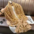 Detail of ochre cotton linen scarf featuring gold leaf print and soft texture - 180*90 / Khaki