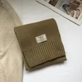 Macro detail of 100% Australian wool scarf featuring woven label and ribbed edges - Matcha Green
