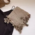 Makro-Detail von atmungsaktivem Leinen-Schal mit natürlicher Textur und Fransenbesatz - Camel