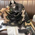 Detail view of cotton-linen scarf with gold ripple pattern and delicate fringe edges - 180*90CM / Black