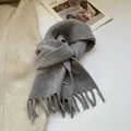 Detail of grey 100% wool knitted scarf with tassels and rectangular metal logo tag - Light Gray