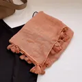 Details des korallenrosa Leinenschals mit Fransenkanten und feiner Stoffstruktur - Orange