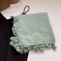 Dettaglio della sciarpa in lino e cotone verde menta con frange e trama del tessuto - Verde