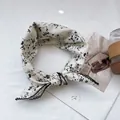 Close-up of floral linen scarf with black lace trim and small flower patterns - White