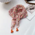 Detailansicht eines floralen Baumwoll-Leinen-Schals mit hellen orangefarbenen Quasten - Pfirsichrosa