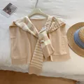 Close-up of beige striped knit shawl wrap with tie-front detail and retail hang tag - Off White