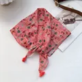 Detailaufnahme des rosa Quadrattuchs mit Reitersport-Print und roten Quasten - Rosa Pferd