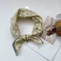Detail of floral cotton linen scarf with dark green crochet lace border in flat lay - Yellow Branches