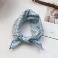 Nahaufnahme des blau geblümten Seidenschals mit fein vernähten Kanten im Detail - Blau Floral
