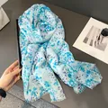 Close-up of light blue floral cotton linen scarf with soft fringe edges and print - 180x90cm / Blue
