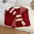 Detail eines rot gestreiften Strickschal-Kragens mit MILLDI-Markenetikett auf Stoff - Rot