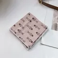 Detail eines hellrosa Leinenschals mit braunem Fischmuster und weißer Nahtverarbeitung - Rosa Goldfisch