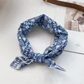 Detail eines blau-weiß bedruckten Baumwollschals, als Haarschmuck geknotet präsentiert - Geometrisch Blau