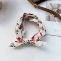 Primer plano de un pañuelo de algodón floral rojo sobre un fondo de revista elegante - Blanco Crema con Girasoles Rojos
